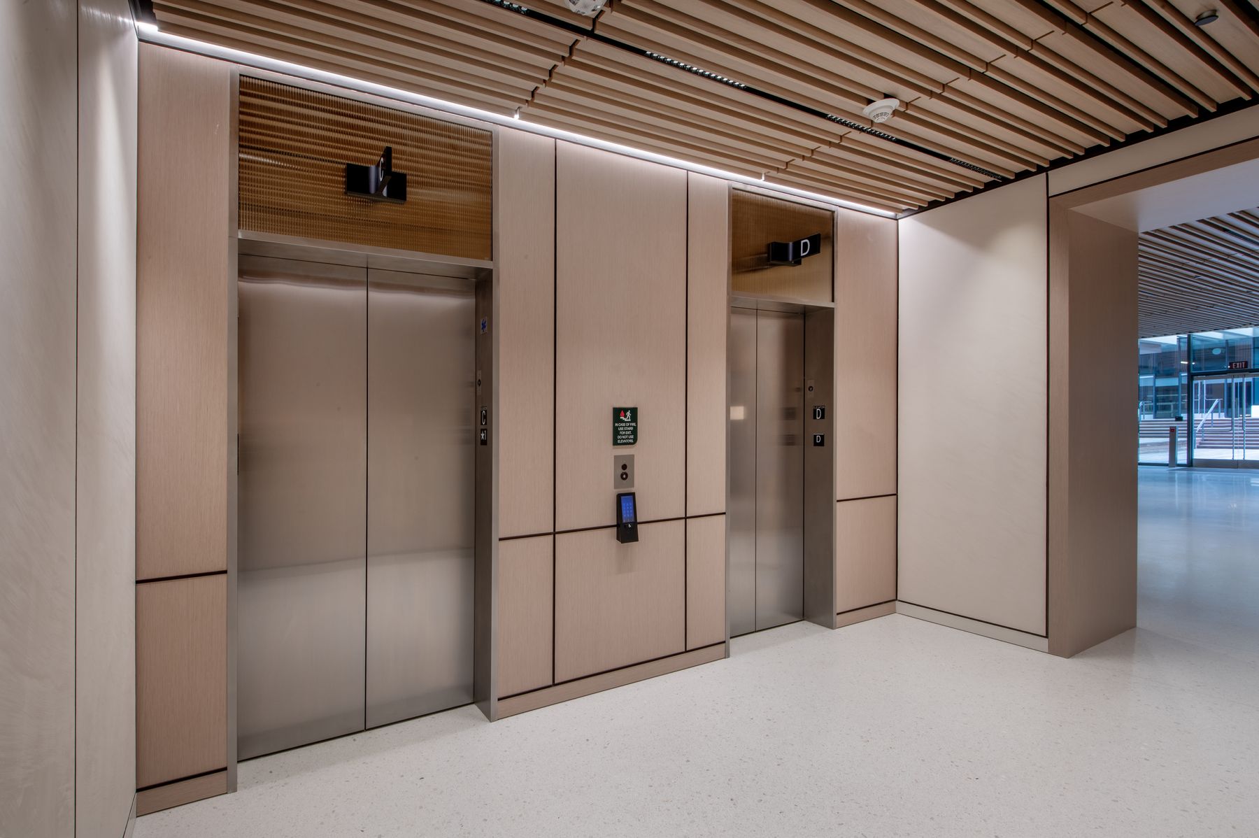 A pair of passenger elevators in a modern office lobby
