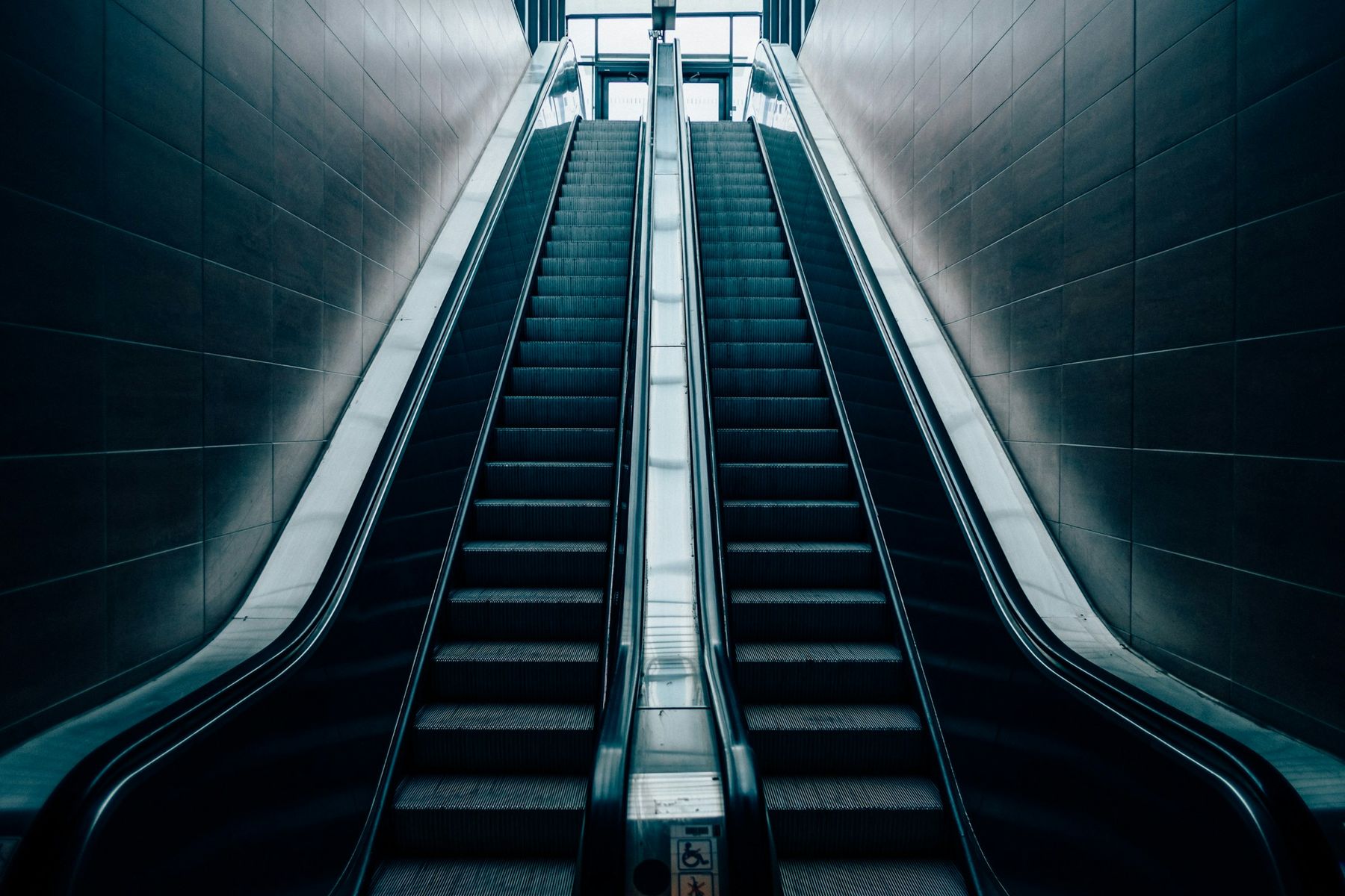 Twin escalators rising through a concourse